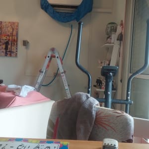 מזגן מכוסה בכיסוי כחול עם סולם לידו