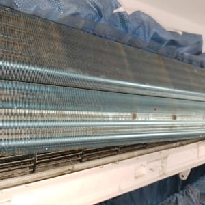 סליל מתכת של מזגן עם לכלוך ואבק