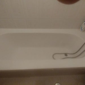 אמבטיה עם ברז ידני ומוצרי טיפוח על הקצה