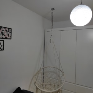 כיסא תלוי מחובר לתקרה בשרשרת מתכת