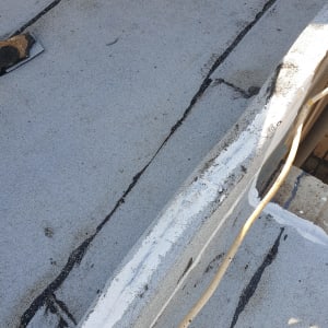 סדקים באיטום גג עם חומר איטום לבן ושחור