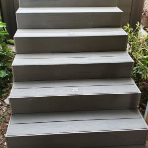 מדרגות עץ אפורות עם צמחייה מסביב