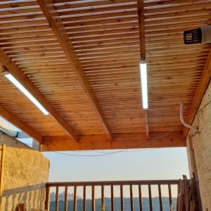 תקרה מעץ עם תאורה ומעקה עץ