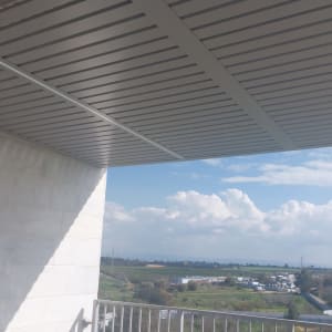 פרגולה מאלומיניום עם קורות אופקיות על מרפסת