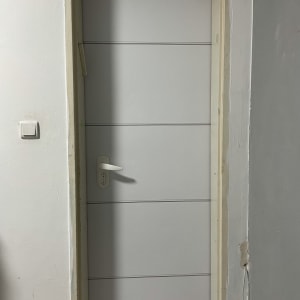 דלת לבנה עם ידית לבנה במסגרת קיר