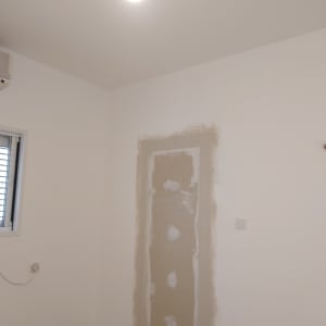 קיר עם תיקוני גבס בצבע לבן