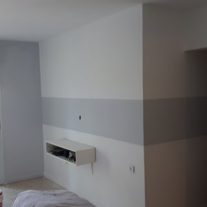 סולם ודלי צבע בחדר צבוע חלקית