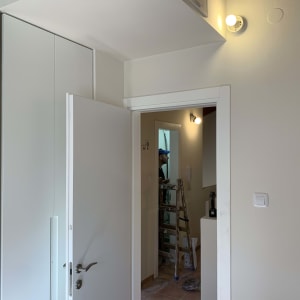 חשמלאי עובד על סולם ליד מתגי תאורה