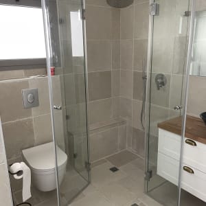 מקלחת עם דלתות זכוכית וראש גשם