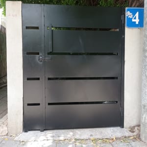 שער מתכת שחור עם מספר ארבע על שלט כחול