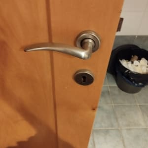 ידית דלת מתכתית ומנעול על דלת עץ