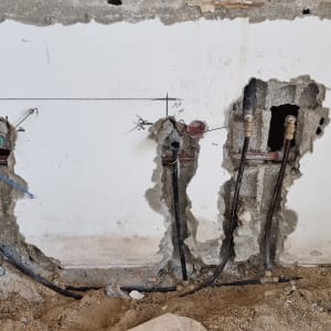 קיר עם חורים וצינורות חשמל במהלך שיפוץ