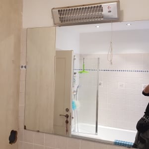 מראה גדולה בחדר אמבטיה עם דלת זכוכית למקלחת