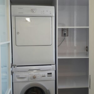 מכונת כביסה ומייבש בארון עם מדפים