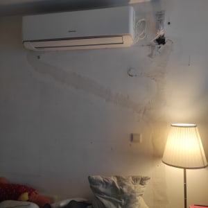 מזגן מותקן על קיר עם חוטי חשמל גלויים