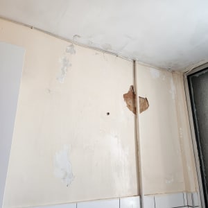 קיר עם קילופי צבע ותיקוני טיח