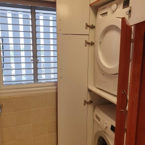 ארון עץ עם דלתות פתוחות ומכונות כביסה