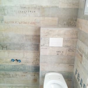 שירותים מותקנים על קיר עם אריחים בעיצוב תעשייתי