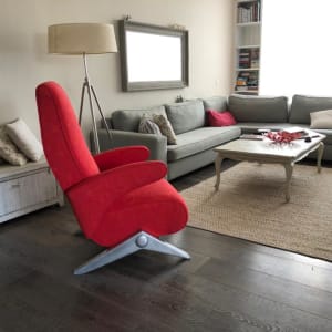 כורסה אדומה מרופדת ליד ספה אפורה