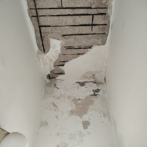 קיר מתקלף עם טיח חשוף וסדקים