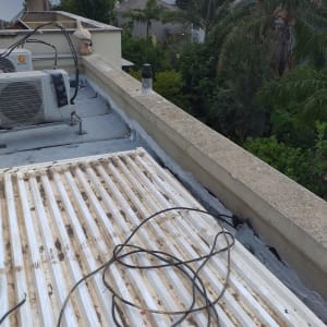 גג עם חומר איטום ליד מזגן וכבלים