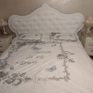 מיטה עם מצעים מעוטרים בפרחים ופרפרים