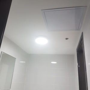 פתח מיזוג אוויר בתקרה לבנה בחדר אמבטיה