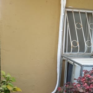 צינור מזגן לבן מחובר לקיר חיצוני