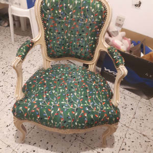 כיסא מרופד בבד ירוק עם דוגמת פרחים צבעונית