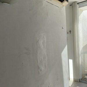 קיר עם תיקוני טיח מתחת למזגן