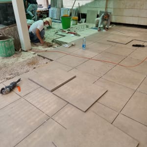 עובדים מתקינים אריחים על רצפה בחוץ