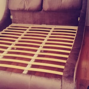 מיטה מרופדת עם מסגרת עץ חשופה