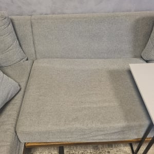 כרית ישיבה אפורה על ספה עם שולחן צד