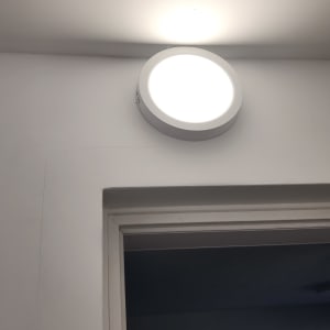 מנורת תקרה עגולה מוארת על קיר לבן