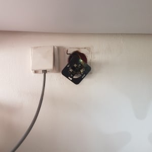 שקע חשמלי פתוח עם חוטים חשופים בקיר