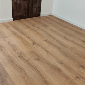 רצפת פרקט עץ בחדר ריק עם דלת פתוחה