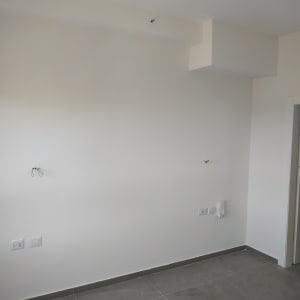 קיר צבוע בלבן עם חוטי חשמל חשופים