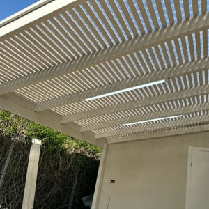 פרגולה מעץ עם קורות לבנות בגינה