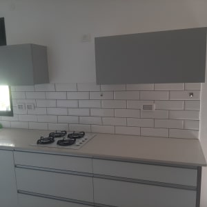 מטבח מודרני עם כיריים גז וארונות אפורים