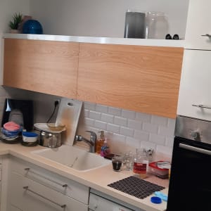 מטבח עם ארונות עץ וכלים על השיש