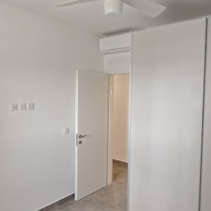חדר ריק צבוע בלבן עם דלת, משקוף וארון הזזה לבנים