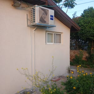 יחידת מיזוג אוויר חיצונית מותקנת על קיר בית