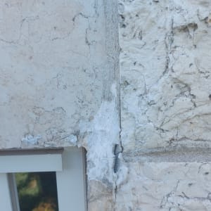 קיר עם סדקים ותיקון בטיח ליד חלון