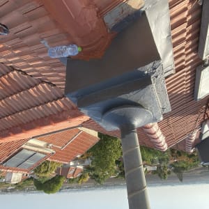 אדם צובע גג רעפים עם מברשת צבע