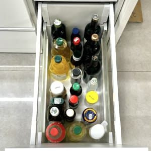 בקבוקים מסודרים במגירת מטבח פתוחה