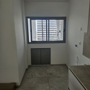 חדר ריק עם חלון ודלתות ארון תחתונות