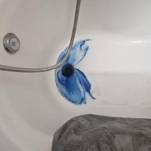 אמבטיה עם כתם כחול ומגבת אפורה