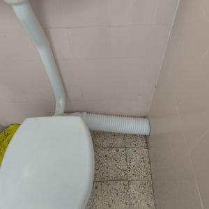 אסלה וצינור ניקוז שרשורי בחדר רחצה ביתי