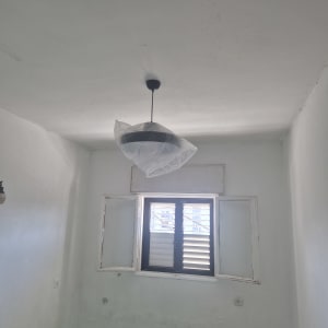 מנורה תלויה בחדר עם חלון פתוח