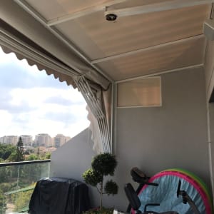 סוכך בד מתוח על מסגרת מתכת במרפסת